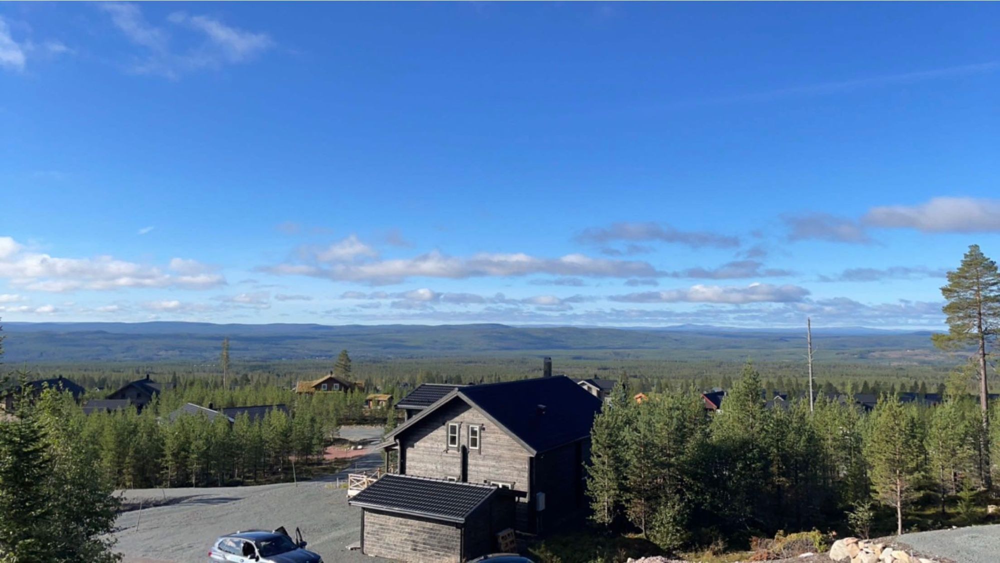 Utsikt över husen och fjällandskapet en sommardag