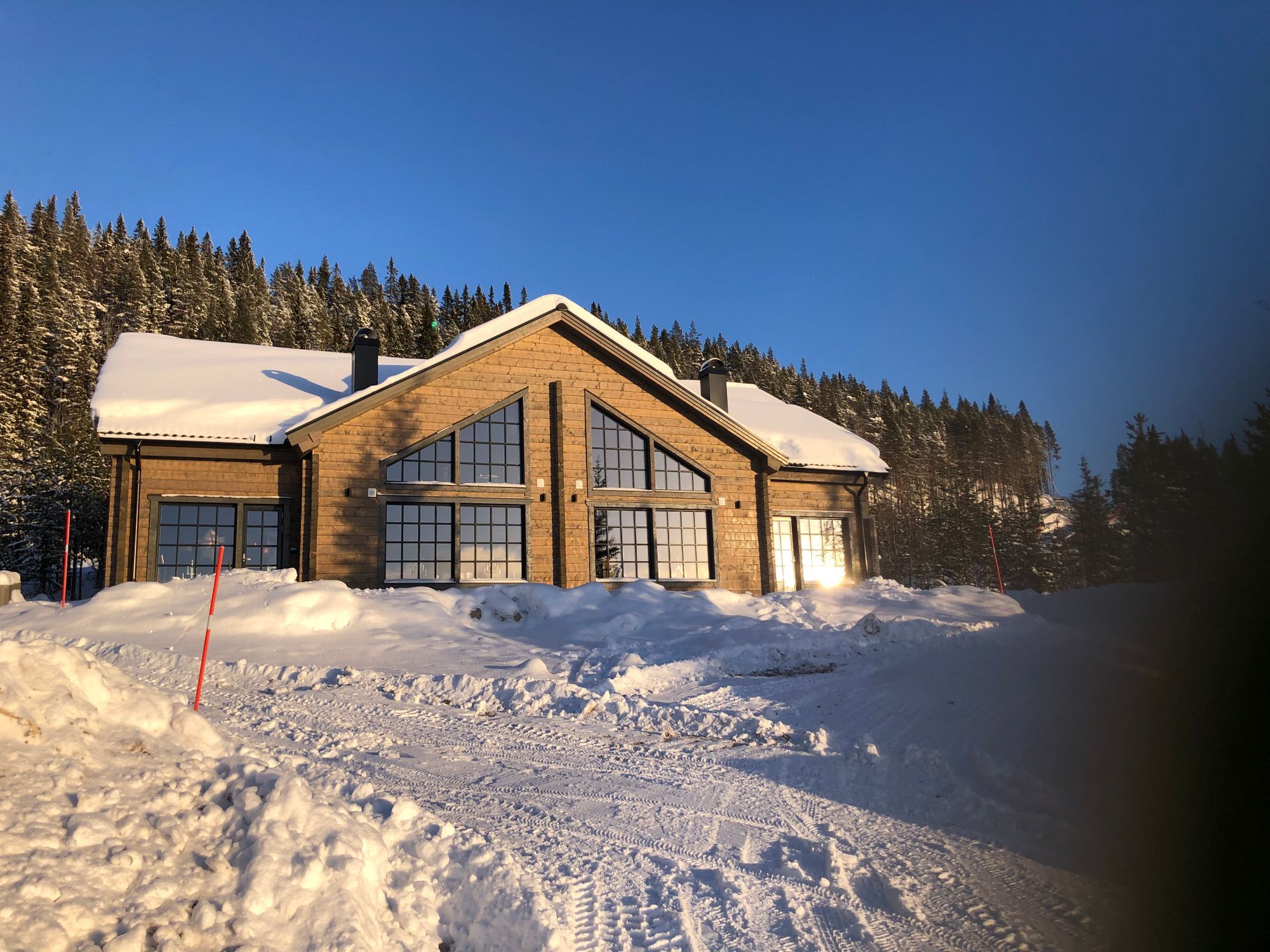 Taurusvägen 15 – parhuset i timmer en klar vinterdag med djup snö
